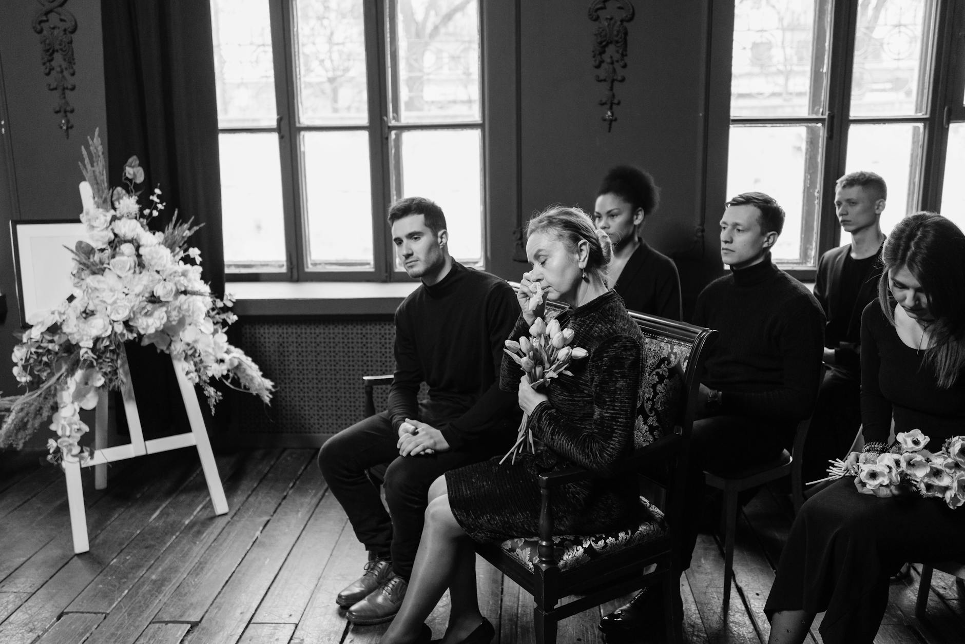 Rodzina przy trumnie wspierająca się podczas pogrzebu