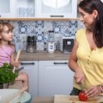 Mama i córka gotują razem w nowoczesnej, przytulnej kuchni