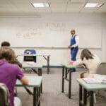 Indywidualizacja pracy: jak wykorzystać obserwację do planu dnia w grupie Nauczyciel akademicki nadzoruje studentów podczas pisania egzaminu